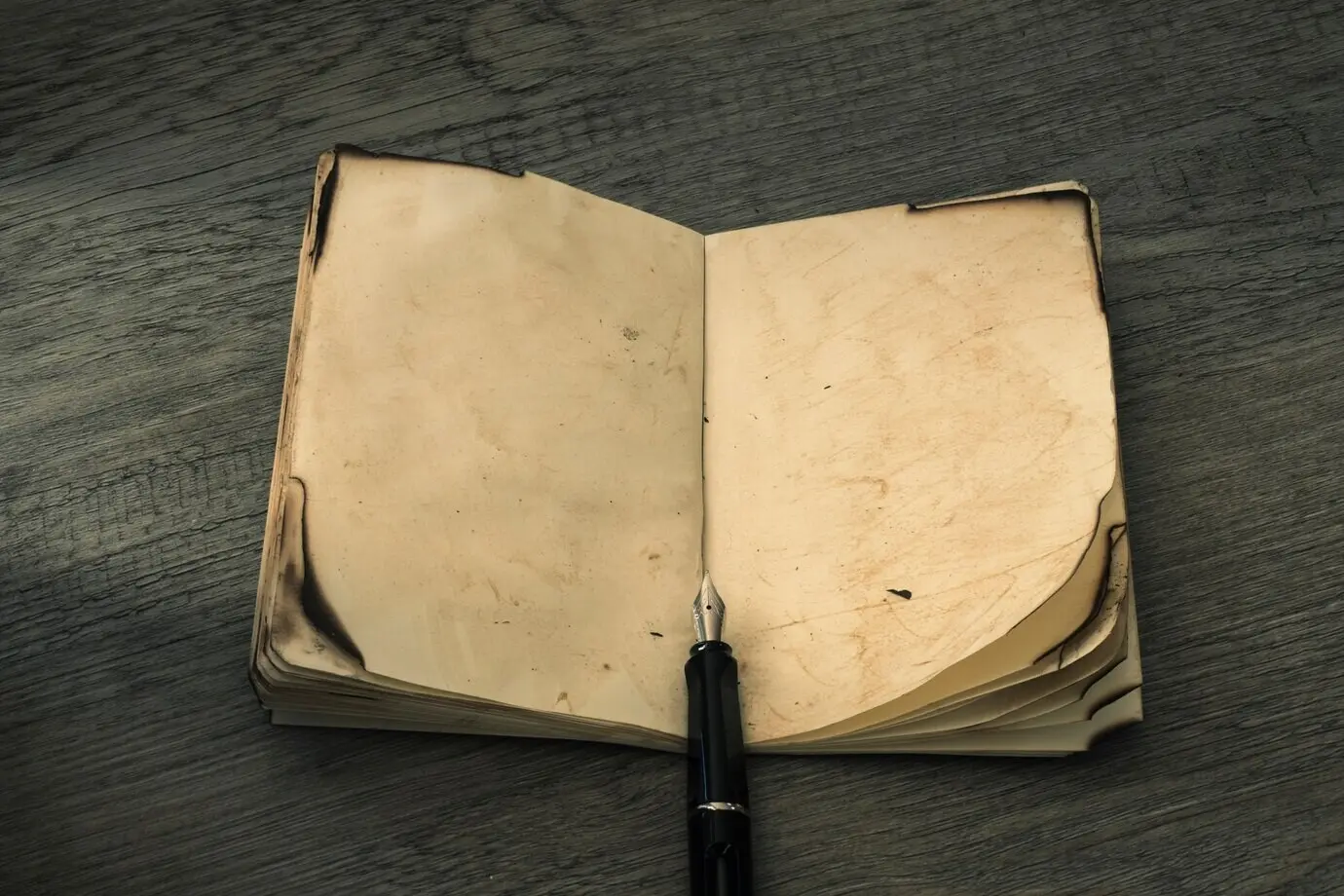 Füllfederhalter in der Nähe eines antiken Notizbuchs
